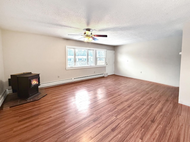 unfurnished living room with a baseboard radiator, a textured ceiling, ceiling fan, a wood stove, and hardwood / wood-style flooring