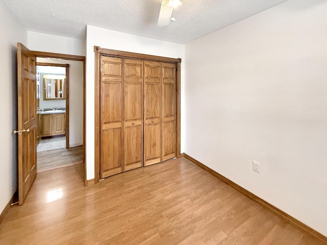 unfurnished bedroom with ceiling fan, light hardwood / wood-style flooring, and a textured ceiling