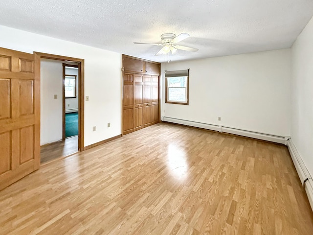 unfurnished bedroom with ceiling fan, baseboard heating, and multiple windows