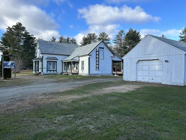 view of front of property with a front yard, a garage, and an outdoor structure