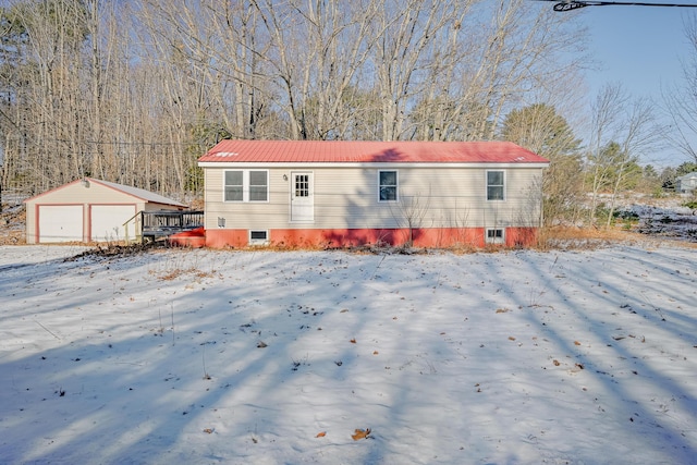 exterior space with a garage, an outbuilding, and a wooden deck