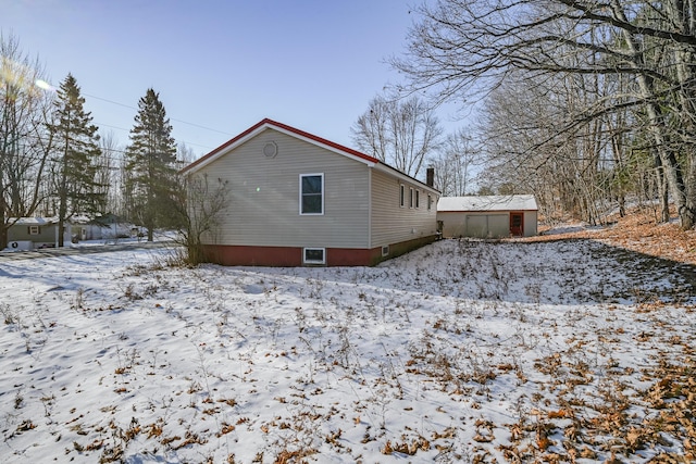 snow covered property featuring a shed