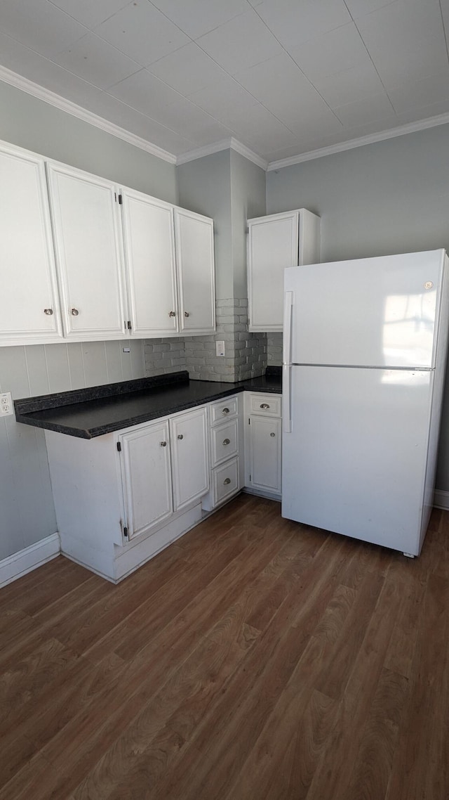 kitchen with white cabinetry, white fridge, tasteful backsplash, dark hardwood / wood-style floors, and ornamental molding