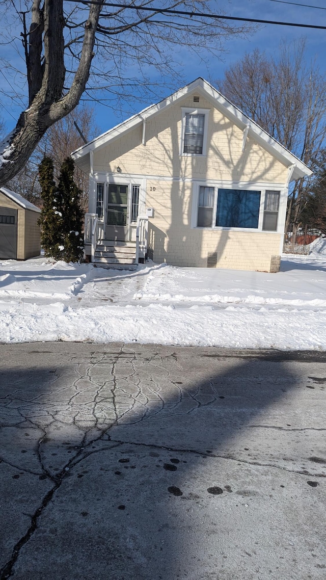 snow covered property featuring a storage unit