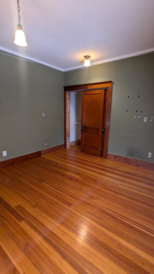 unfurnished room featuring hardwood / wood-style flooring and ornamental molding