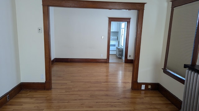 hallway featuring radiator and light hardwood / wood-style flooring