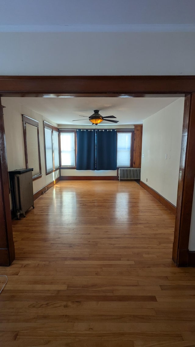 unfurnished room with wood-type flooring and radiator heating unit