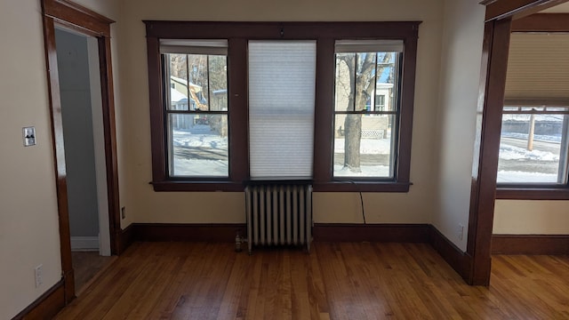 spare room featuring hardwood / wood-style flooring and radiator