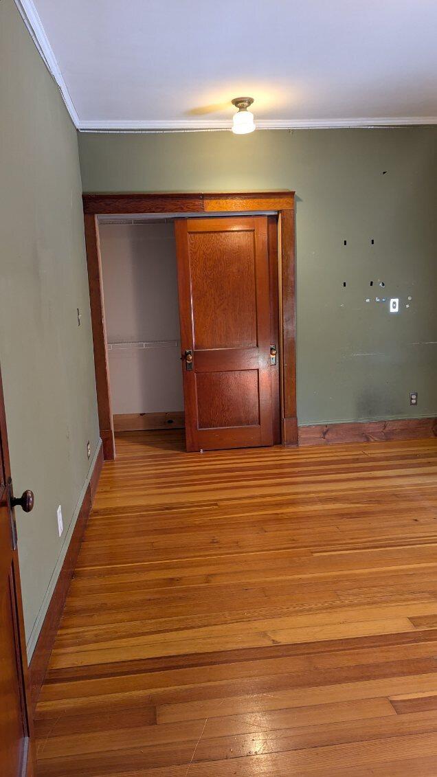 interior space with light hardwood / wood-style flooring and ornamental molding