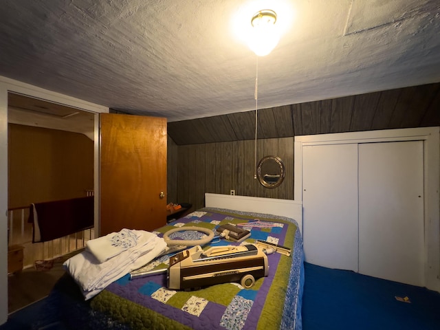 bedroom with lofted ceiling, a closet, and wooden walls