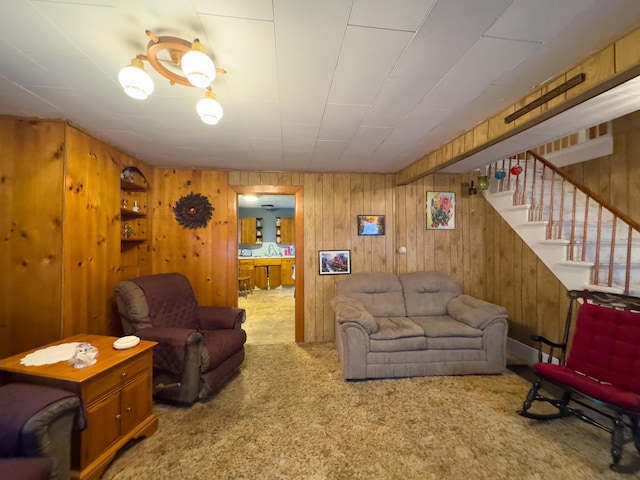 carpeted living room featuring wood walls