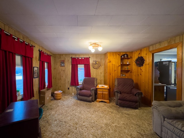 carpeted living room with wood walls