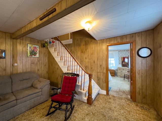 carpeted living room featuring wooden walls