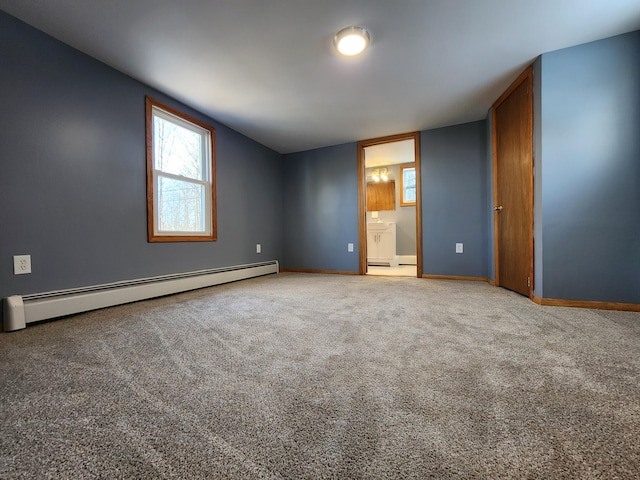 unfurnished bedroom featuring a baseboard heating unit, carpet, and ensuite bathroom