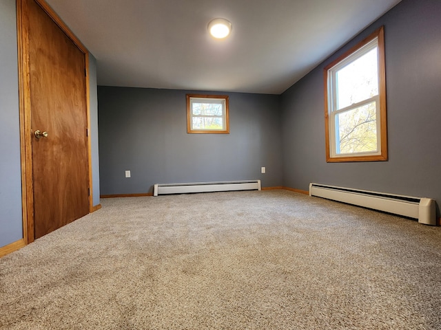 interior space with baseboard heating, plenty of natural light, and carpet flooring