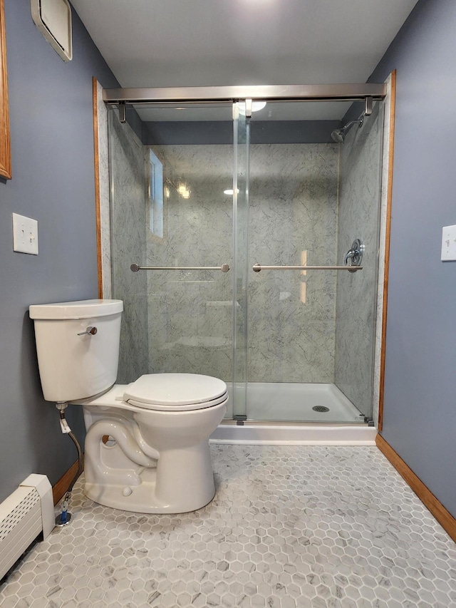 bathroom featuring toilet, baseboard heating, tile patterned floors, and a shower with shower door