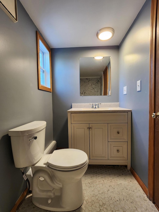 bathroom with toilet, vanity, and a wall mounted air conditioner