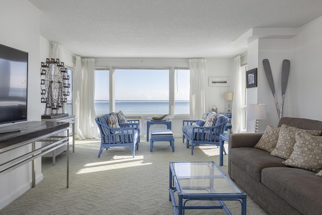 carpeted living room featuring a water view and a textured ceiling