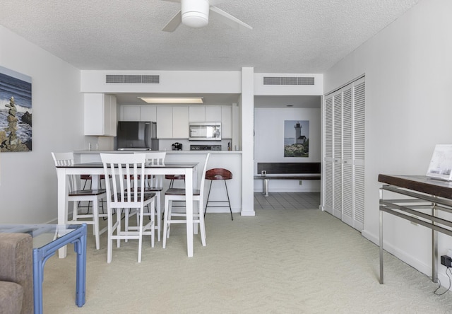 dining area with a textured ceiling and ceiling fan