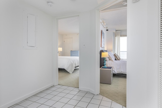 hallway featuring light carpet and electric panel