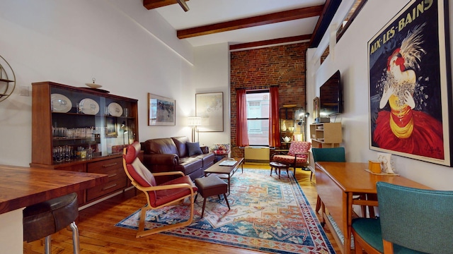 living room featuring beamed ceiling and wood-type flooring