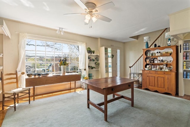 carpeted office space with ceiling fan