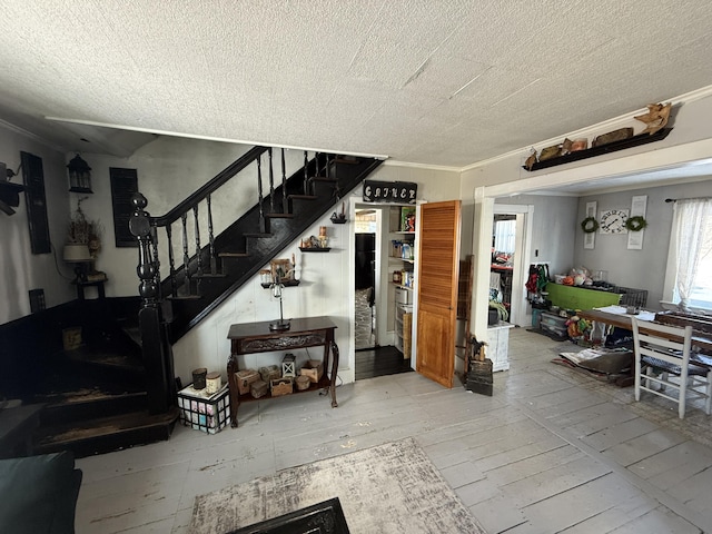 stairway with a textured ceiling and crown molding