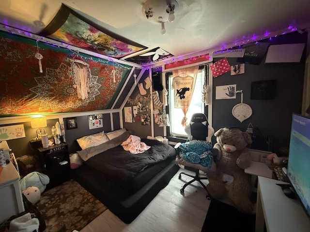 bedroom featuring wood-type flooring and vaulted ceiling