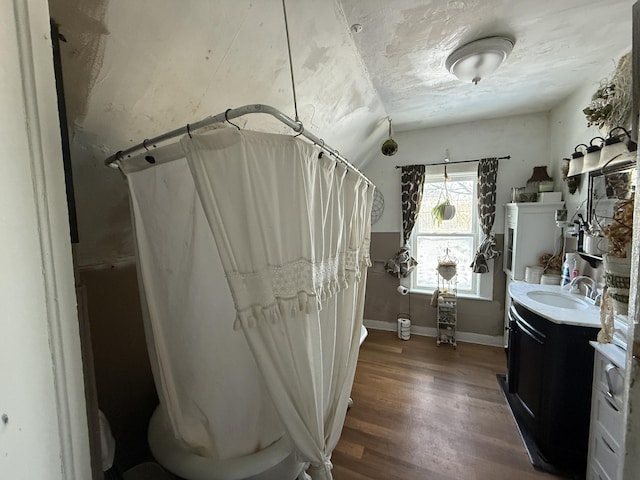 bathroom featuring hardwood / wood-style flooring, a textured ceiling, vanity, and lofted ceiling