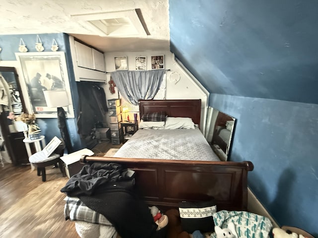 bedroom featuring hardwood / wood-style flooring and lofted ceiling