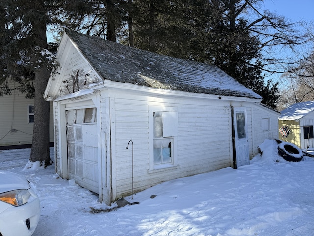 snow covered structure featuring a garage