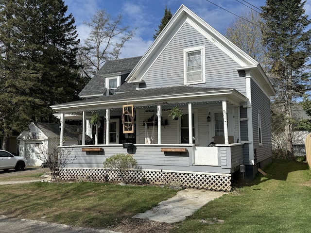 view of front of house featuring a porch, a front lawn, and roof with shingles