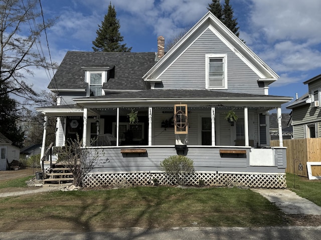 view of front facade with a porch, a chimney, and a shingled roof