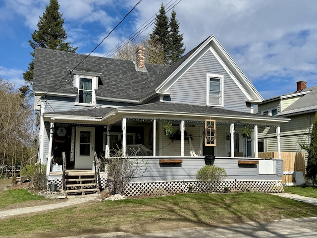 view of front of property featuring covered porch, a shingled roof, and a chimney
