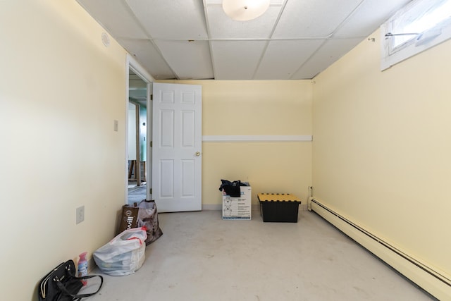 basement featuring a baseboard heating unit and a paneled ceiling