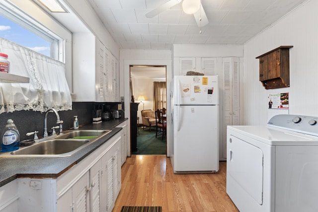 laundry room with ceiling fan, washer / dryer, sink, and light hardwood / wood-style floors