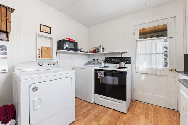 laundry area with light hardwood / wood-style floors and washer and dryer