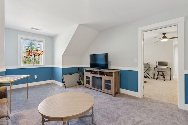 carpeted living area with baseboards and visible vents