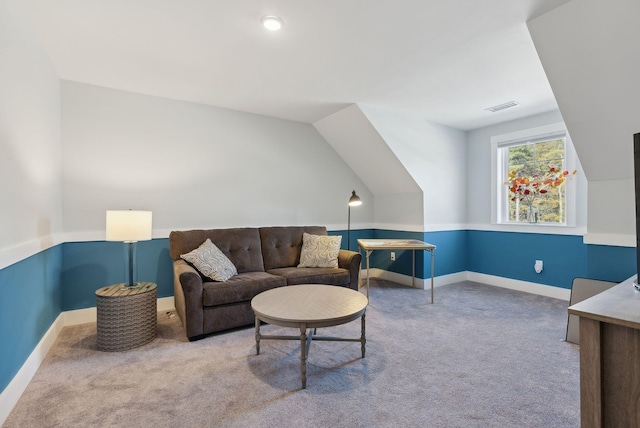 carpeted living area featuring visible vents, baseboards, and lofted ceiling