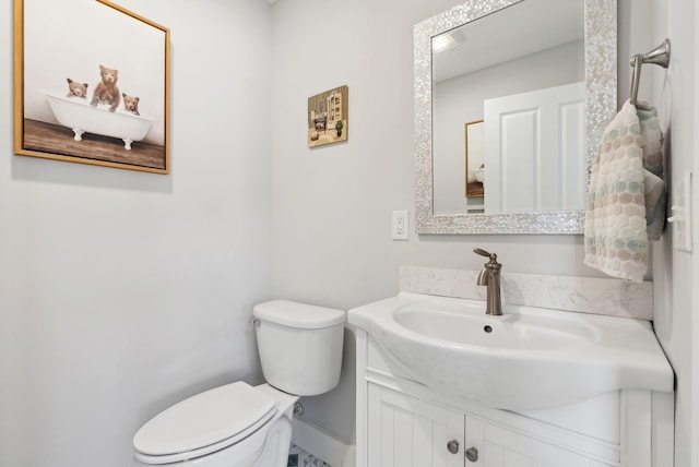 bathroom featuring vanity, toilet, and baseboards