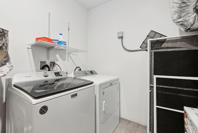 laundry area featuring washer and dryer, laundry area, and light colored carpet