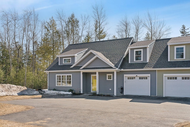 view of front of property with aphalt driveway, an attached garage, and a shingled roof