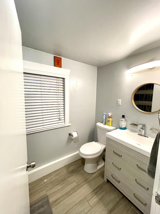 bathroom with hardwood / wood-style flooring, vanity, and toilet