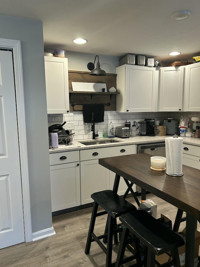 kitchen featuring light hardwood / wood-style floors, decorative backsplash, and white cabinets