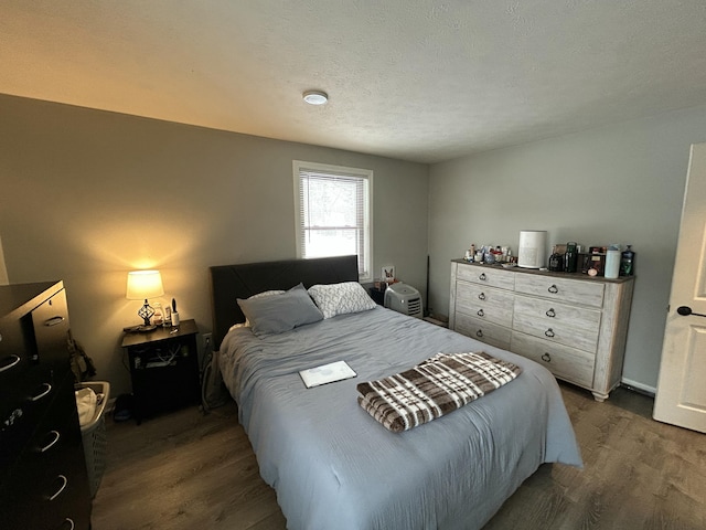 bedroom featuring dark wood-type flooring and a textured ceiling