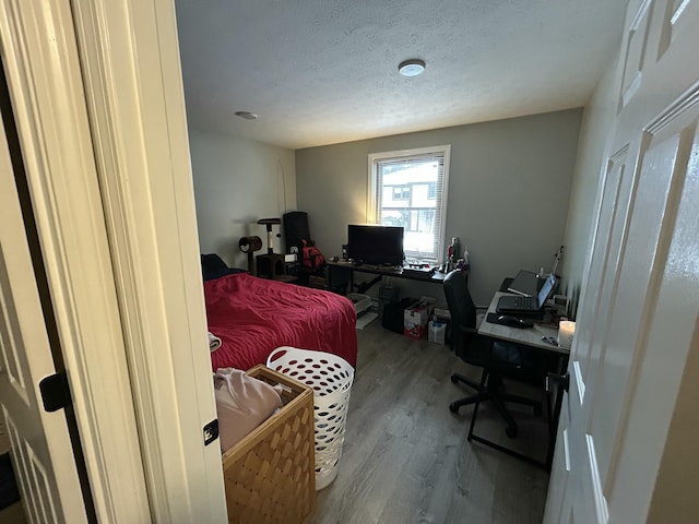 bedroom with hardwood / wood-style flooring and a textured ceiling