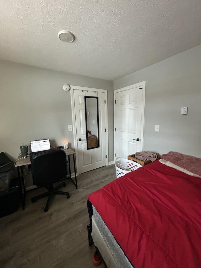 bedroom featuring dark hardwood / wood-style floors and a textured ceiling