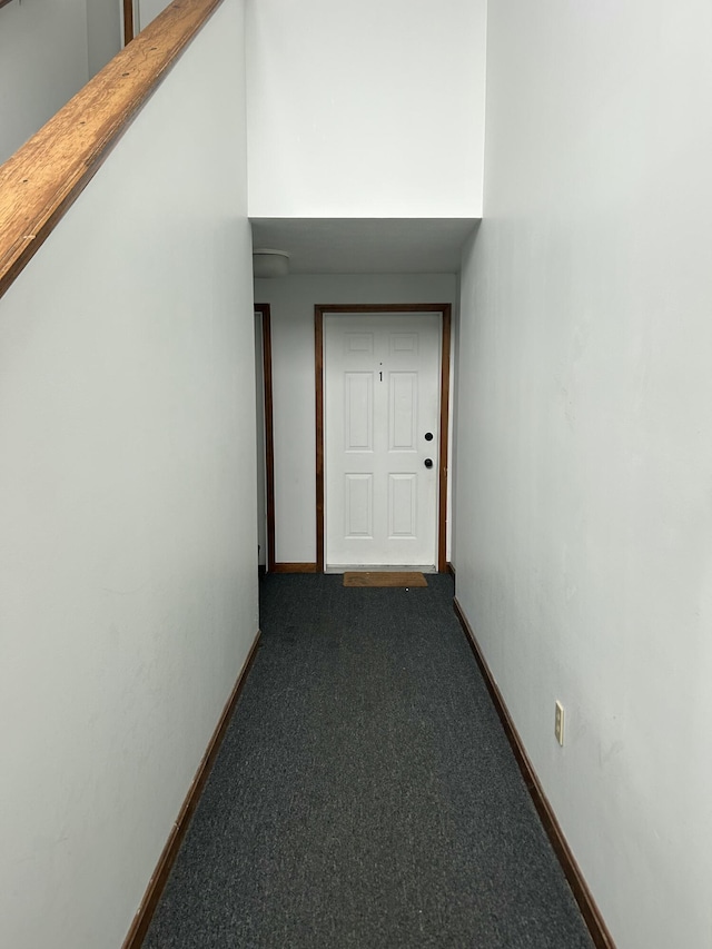 hall featuring dark colored carpet