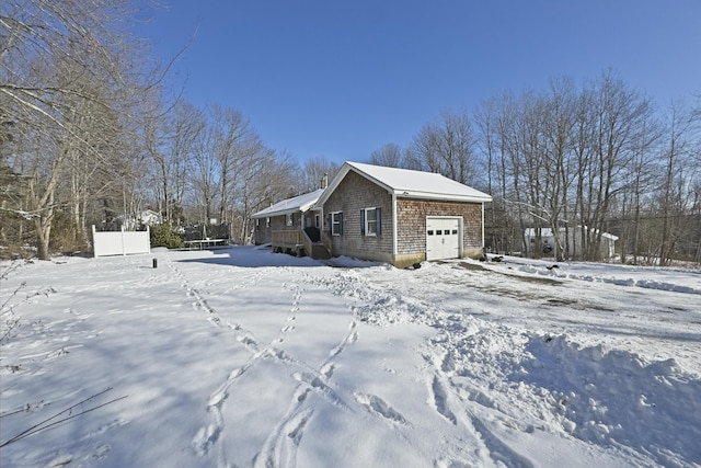 view of snowy exterior featuring a garage