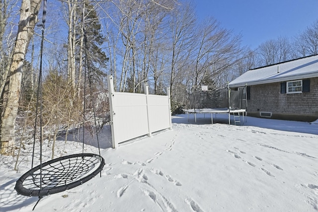 snowy yard with a trampoline